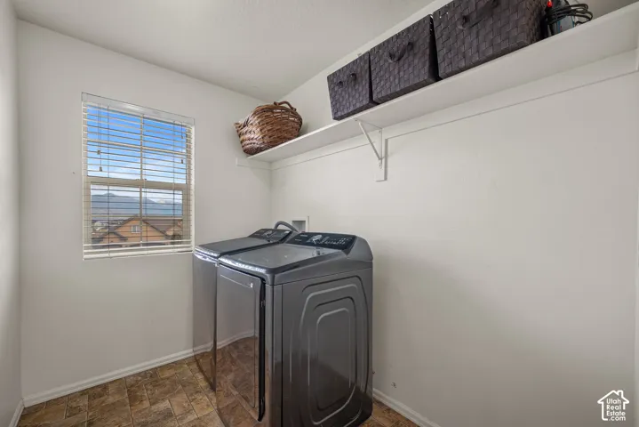 Utility area featuring a window with horizontal blinds, built-in shelving, and patterned tile flooring