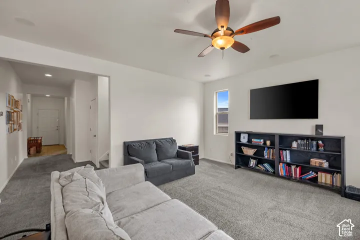 Neutral-toned carpeted flooring, ceiling fan with integrated lighting, and recessed ceiling lights