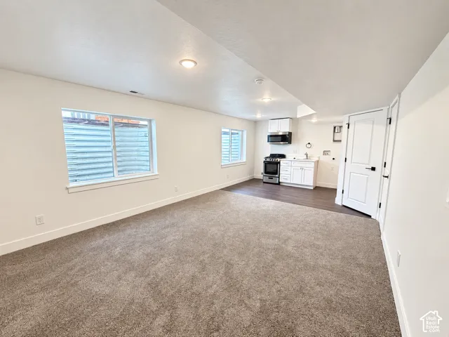 Living area featuring neutral carpeting, recessed lighting, and dual window wells