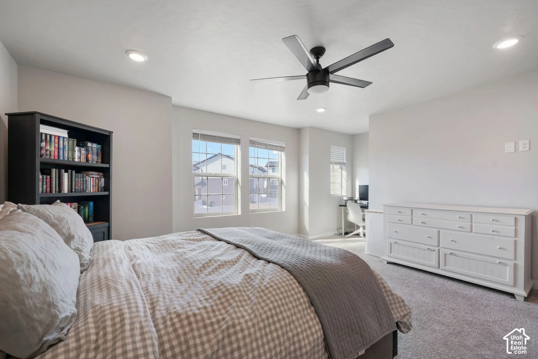 Neutral wall tones, recessed lighting, multi-blade ceiling fan, and carpeted flooring