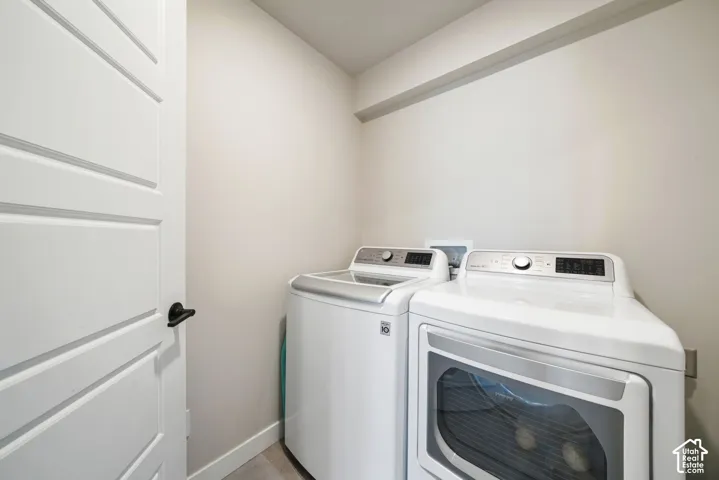 Dedicated laundry area featuring a white four-panel interior door with matte black hardware