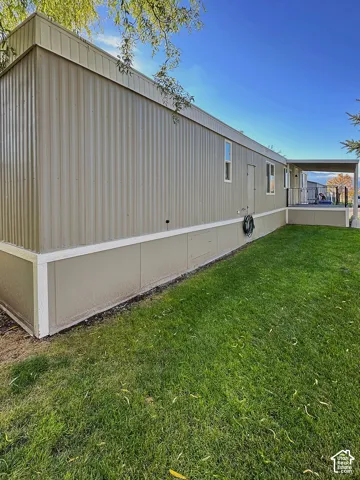 Exterior featuring corrugated metal siding, a solid panel foundation skirting, and a covered entry porch with metal railing