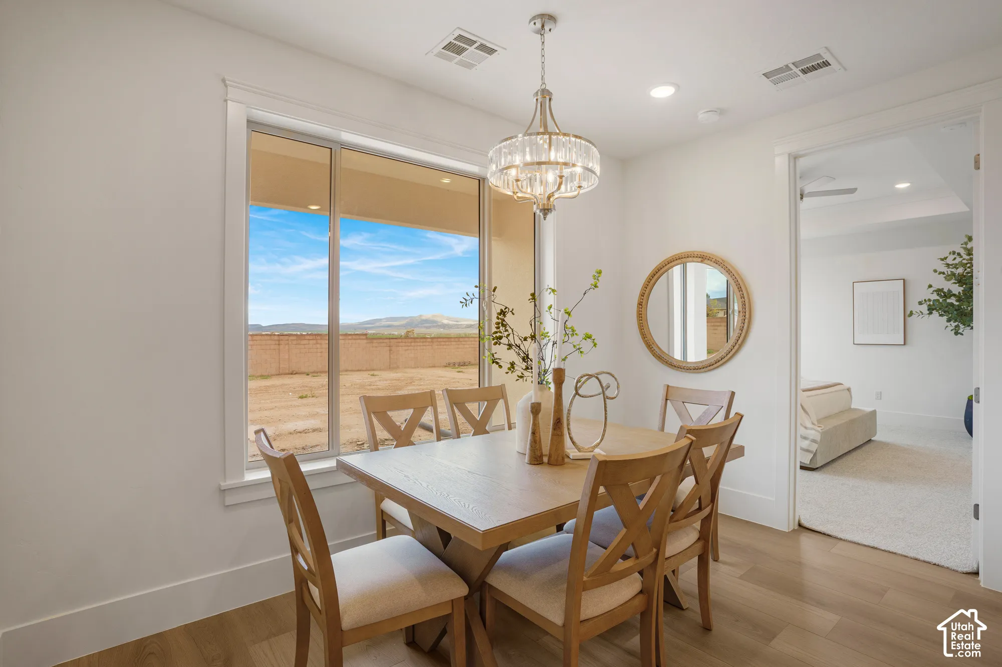 Dining space featuring wood-finish flooring, a multi-light crystal chandelier, and a large window with mountain terrain scenery