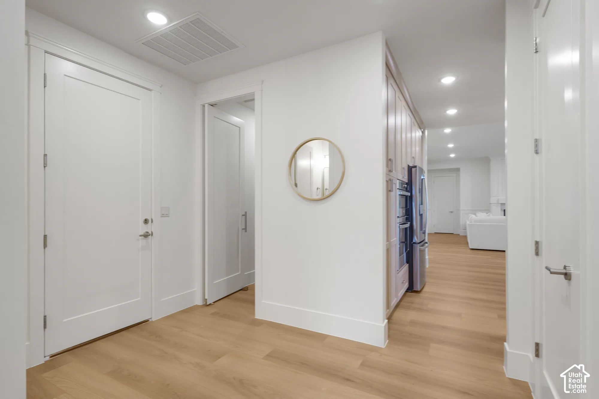 Entryway featuring wood-finish flooring, shaker-style interior doors, recessed lighting, and built-in cabinetry