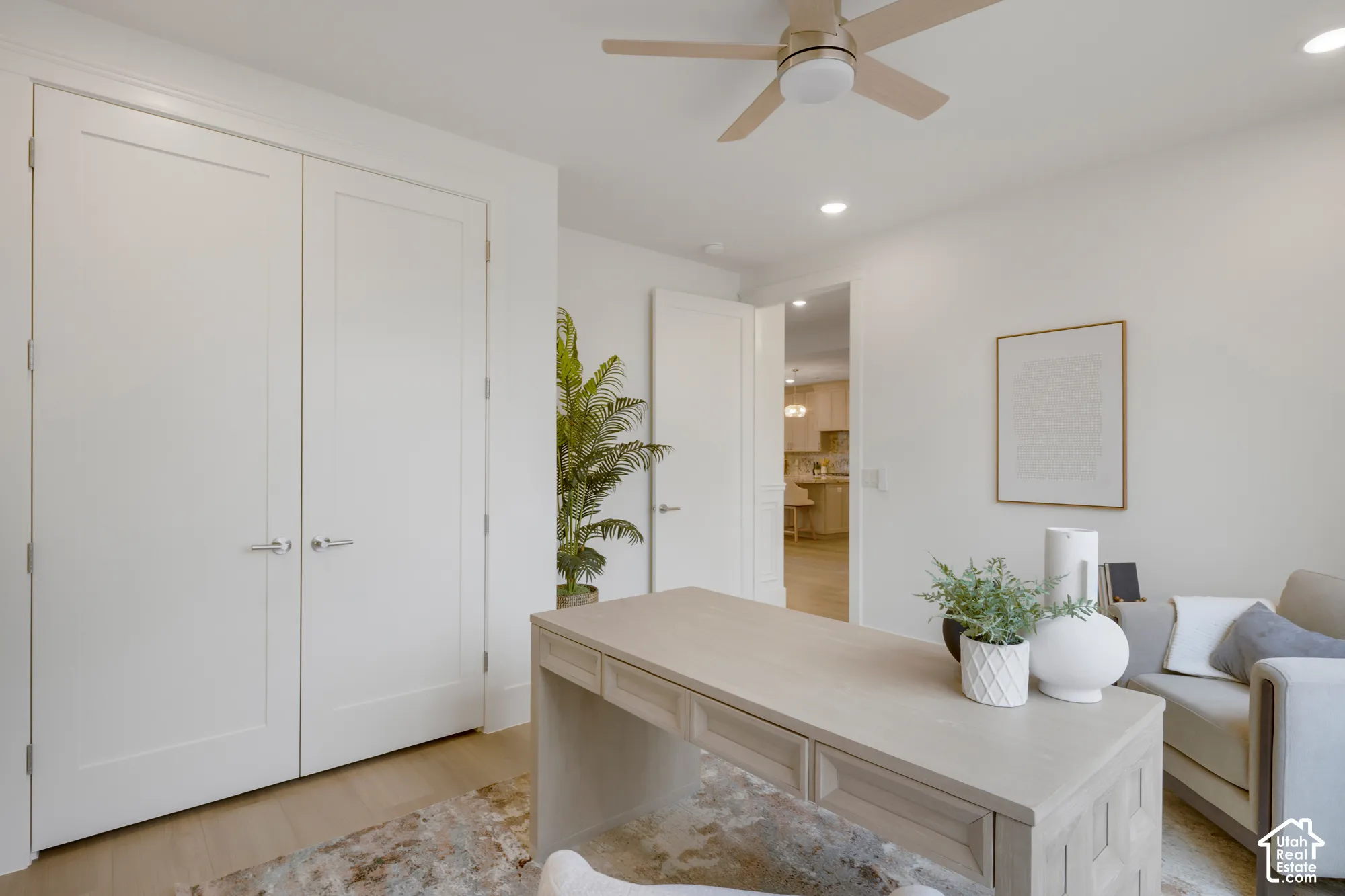 Interior space featuring neutral wall paint, wood-finish flooring, double-door closet with brushed nickel hardware, and a ceiling-mounted fan