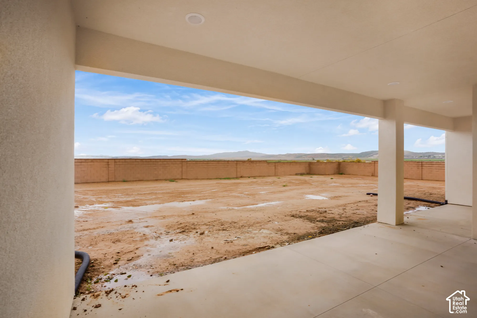Covered concrete patio featuring recessed lighting, masonry perimeter wall, and mountain backdrop