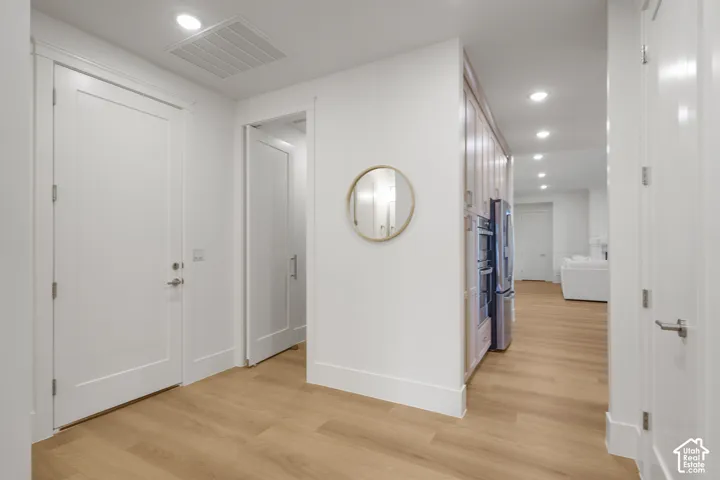 Entryway featuring wood-finish flooring, shaker-style interior doors, recessed lighting, and built-in cabinetry