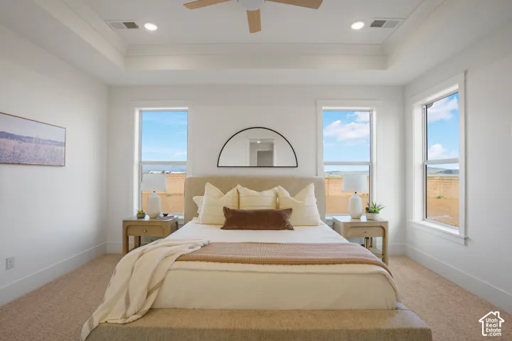 Tray ceiling featuring a central ceiling fan and recessed lighting, accompanied by triple-window configuration and neutral carpet flooring