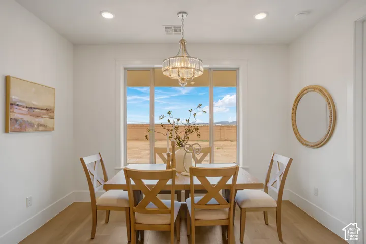 Dining space featuring recessed lighting, a crystal-accented chandelier, wood-finish flooring, and large windows