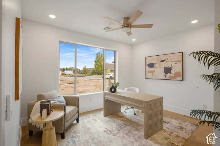 Interior space featuring large-format windows, wood-finish flooring, recessed lighting, and a neutral-toned ceiling fan with integrated light