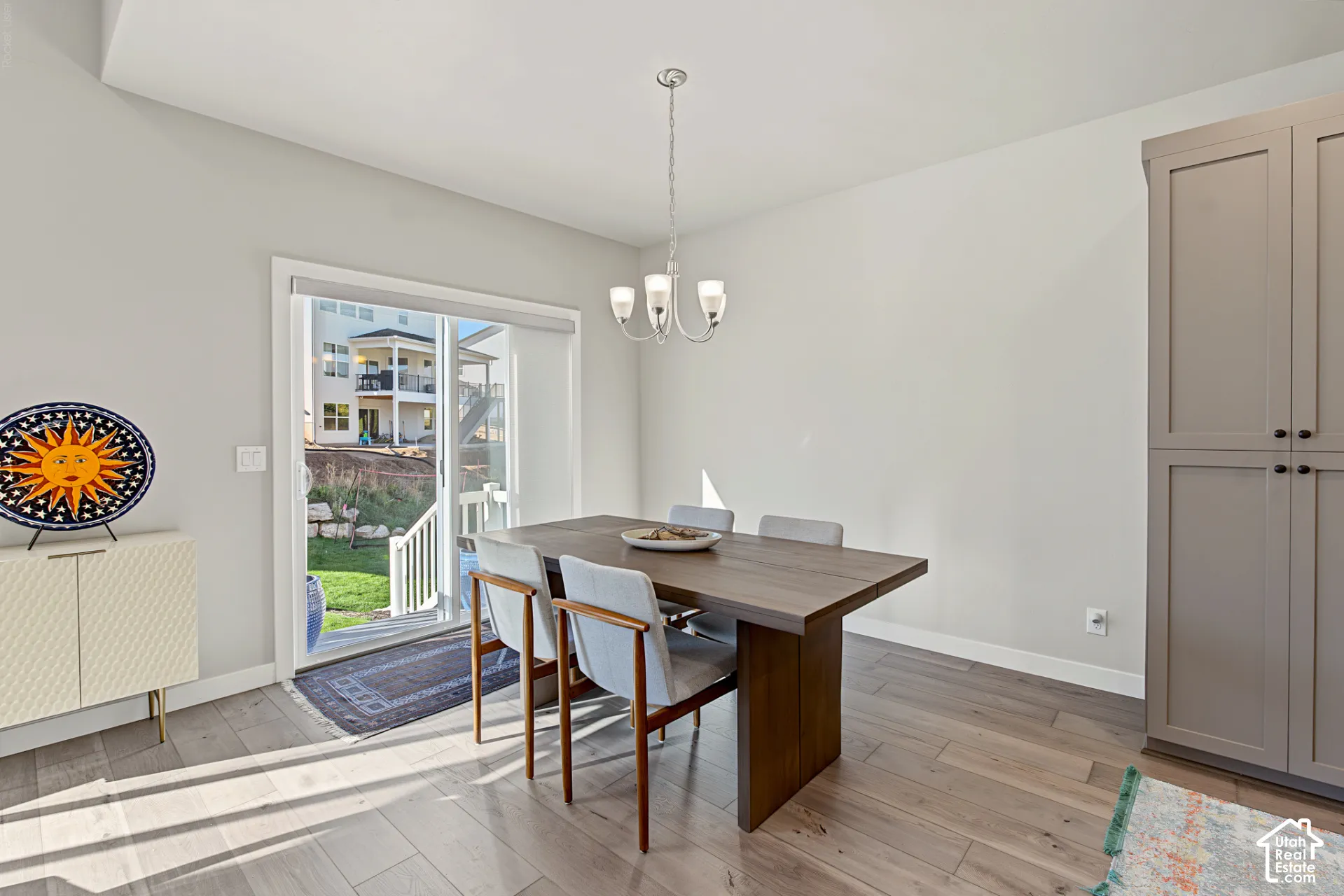 Dining space featuring wood-finish flooring, a neutral color palette, floor-to-ceiling built-in cabinetry, and a sliding glass door