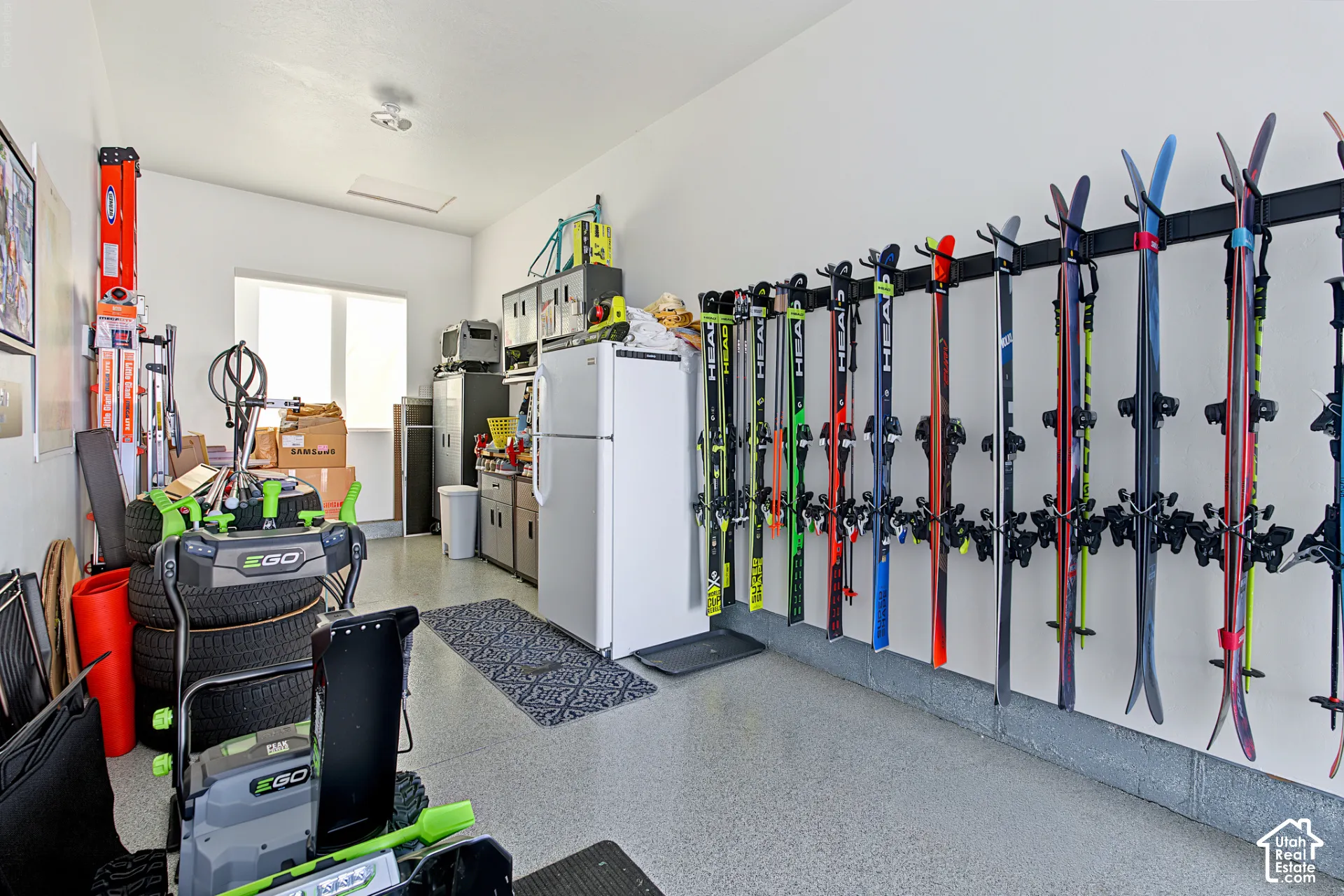 Garage featuring durable epoxy flooring, wall-mounted rack storage system, and built-in cabinetry