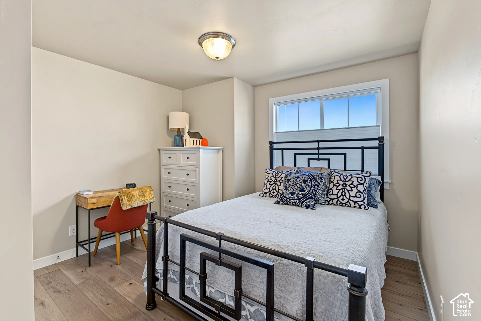 Room featuring wood-finish flooring, neutral wall paint, and a sliding window with clean white trim