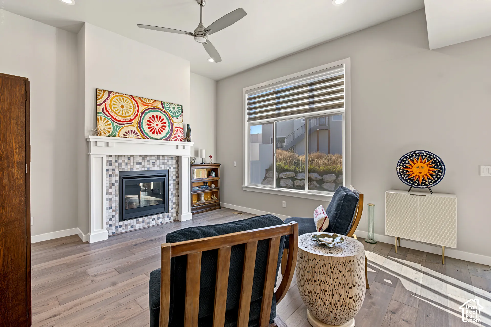 Fireplace featuring a mosaic tile surround and white mantel, high ceilings, wood-finish flooring, recessed lighting, and a modern ceiling fan