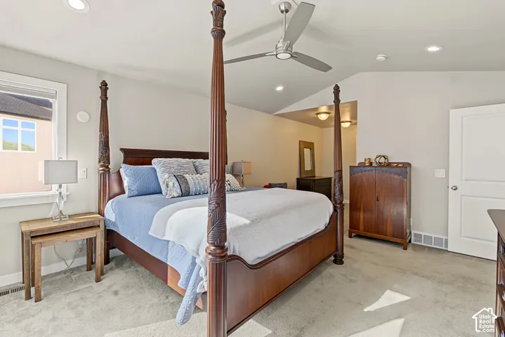 Vaulted ceilings, carpeted flooring, recessed lighting, and a modern brushed-metal ceiling fan