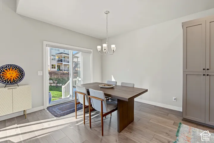 Dining space featuring wood-finish flooring, a neutral color palette, floor-to-ceiling built-in cabinetry, and a sliding glass door