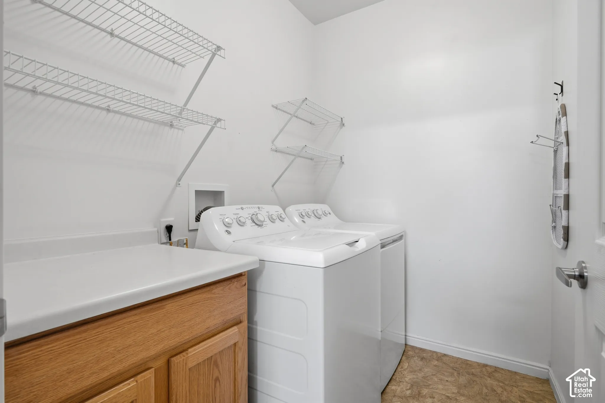 Laundry room featuring built-in cabinetry, a solid-surface countertop, and wire wall shelving