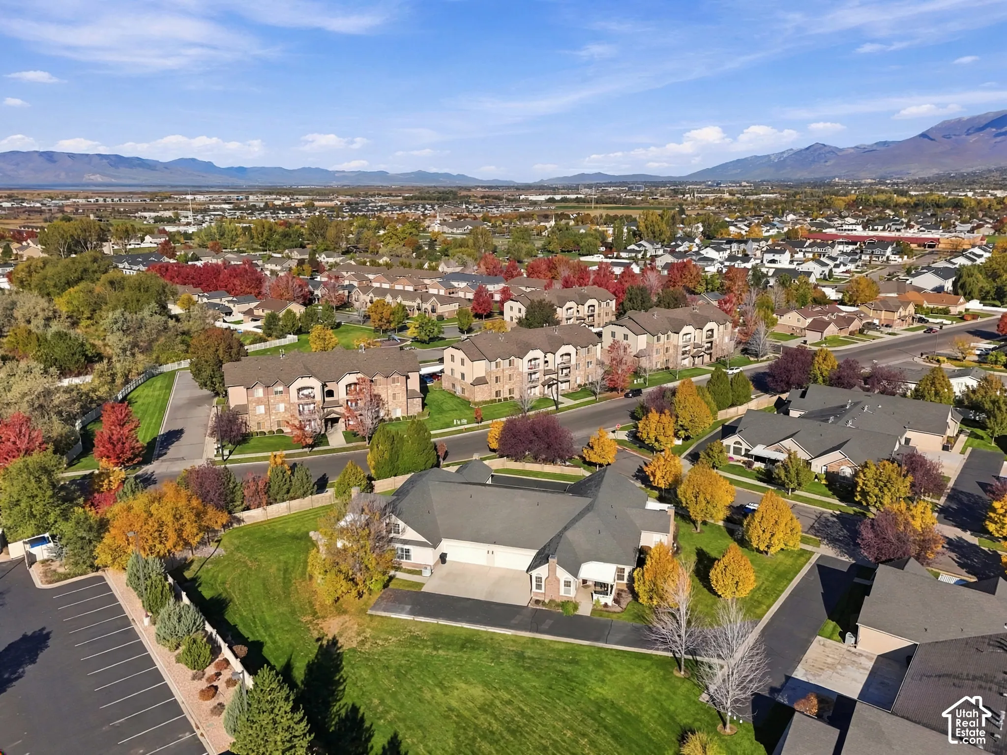 Aerial perspective of multi-story brick facade buildings with asphalt shingle roofing, paved parking areas, and mature landscaping