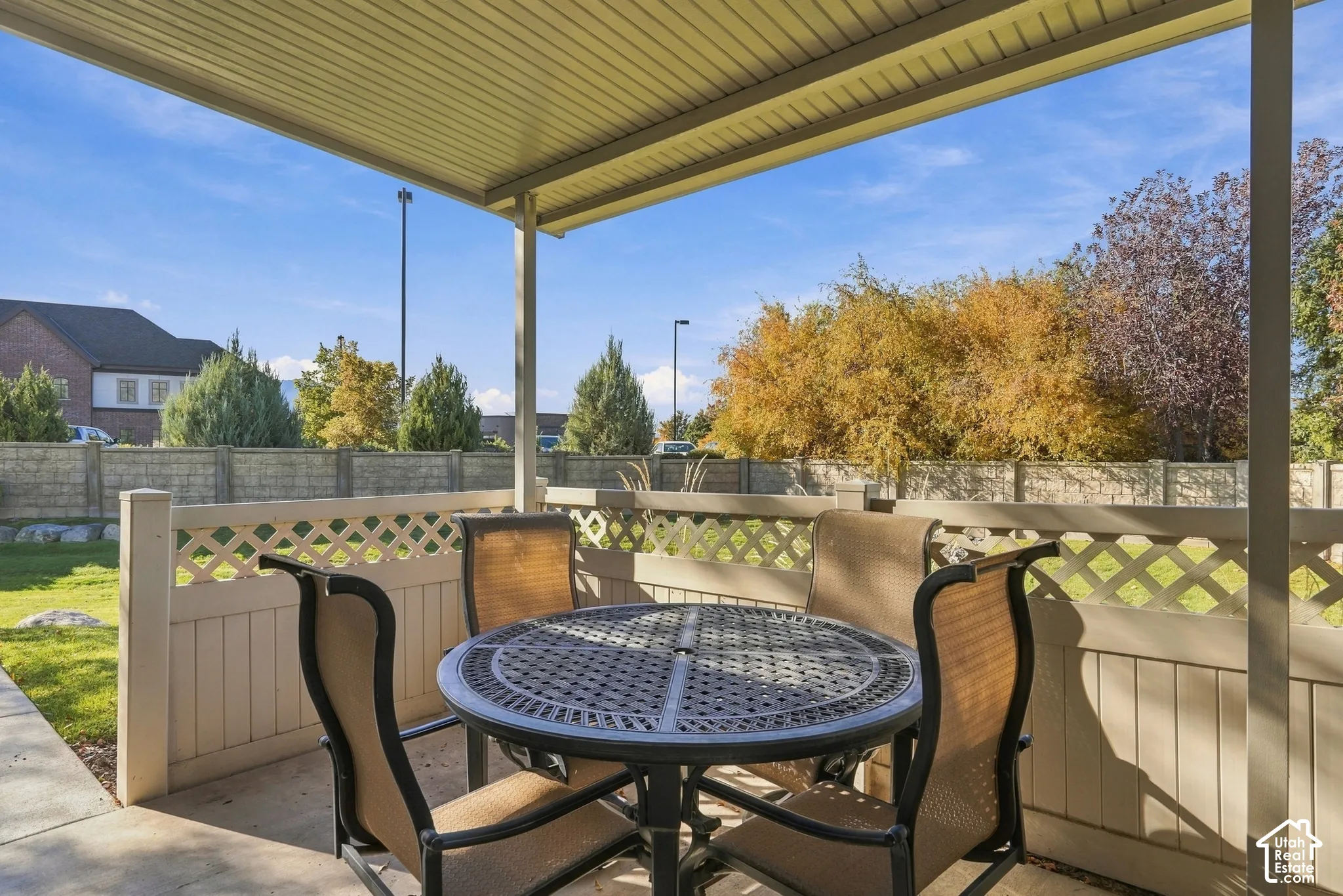 Covered patio featuring a concrete foundation and a lattice-top vinyl privacy fence