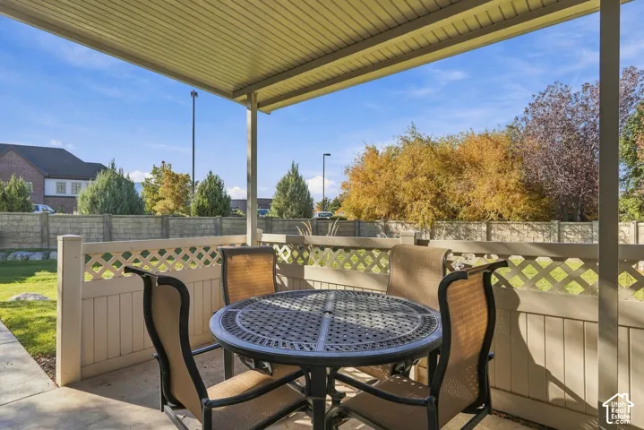 Covered patio featuring a concrete foundation and a lattice-top vinyl privacy fence
