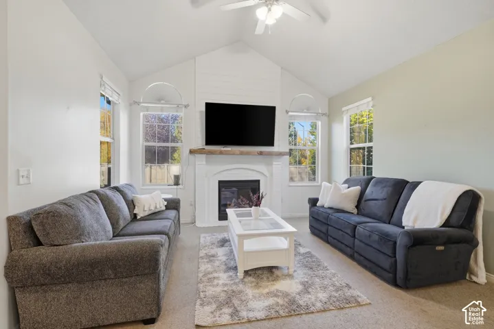 Vaulted ceiling, fireplace with wood mantel, shiplap detailing, and arched windows