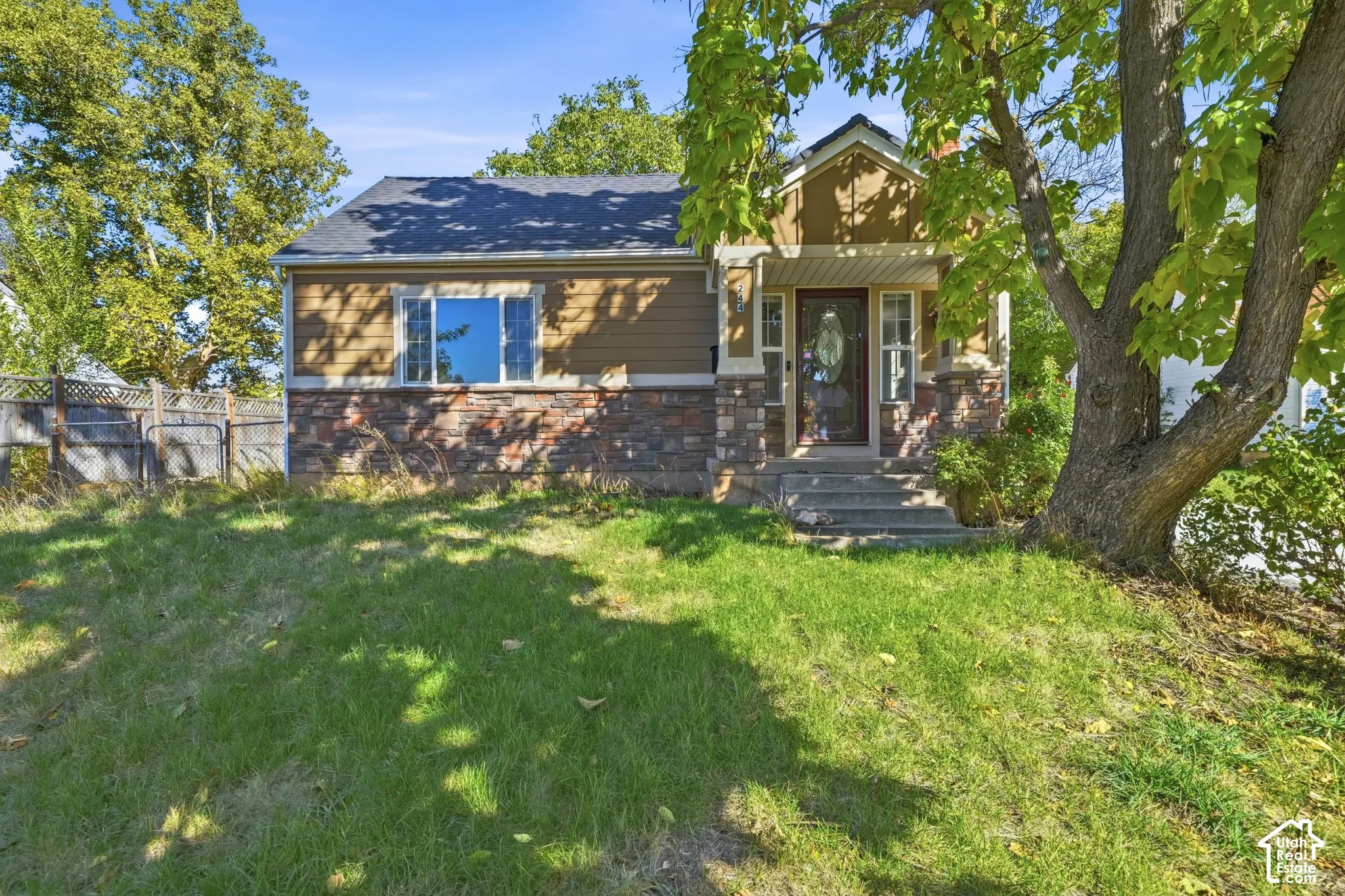 Craftsman-style exterior featuring a stone facade, horizontal siding, covered front porch with tapered columns, and gabled roofline