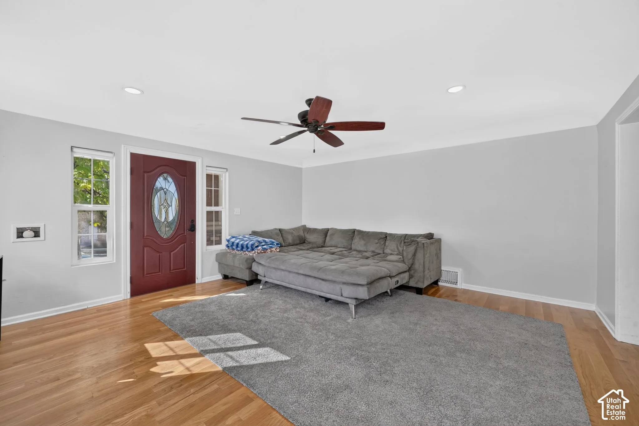 Hardwood flooring, recessed lighting, ceiling fan with light fixture, and an exterior door with an oval glass insert