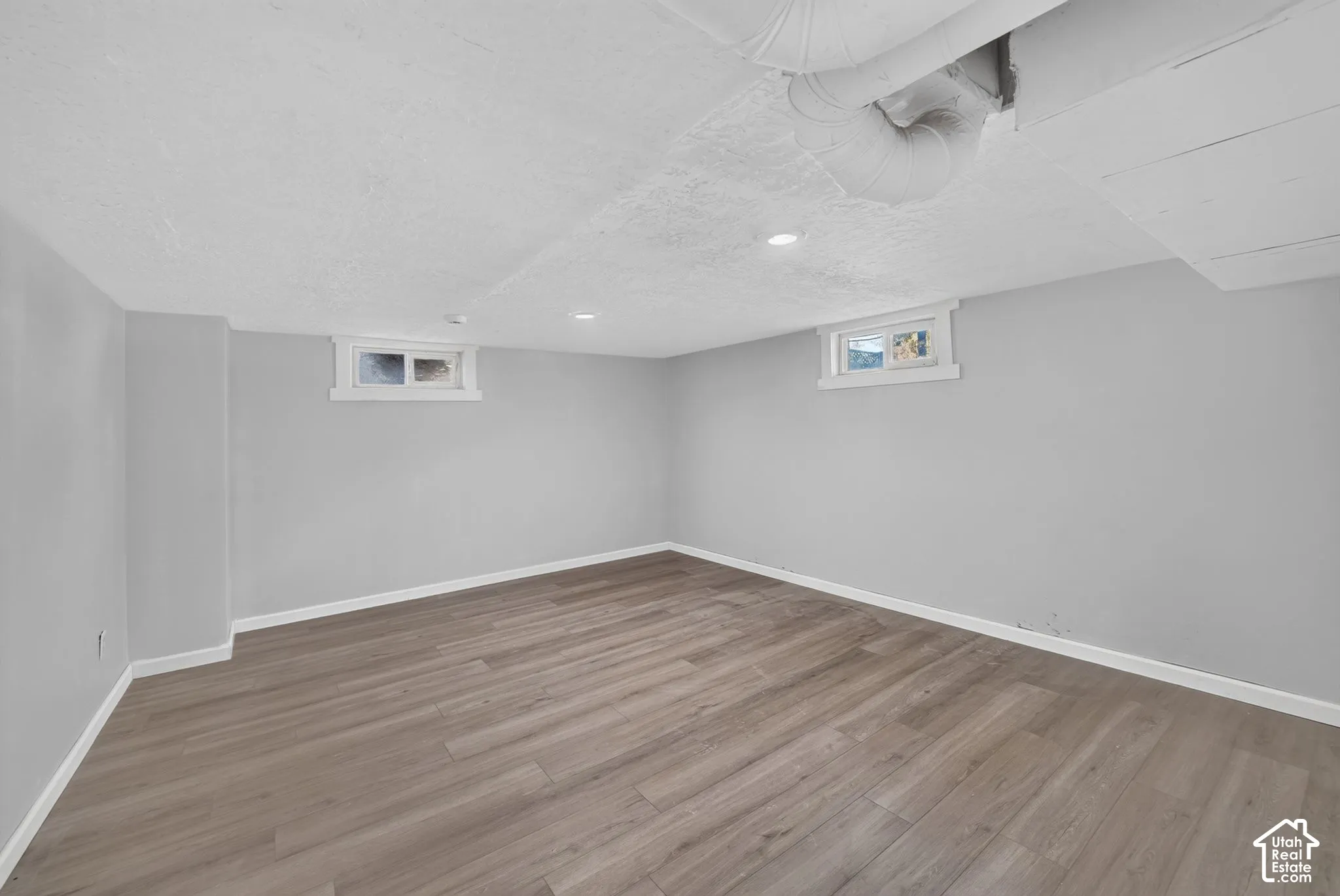 Interior room featuring wood-finish flooring, light gray walls, recessed lighting, and dual inset windows