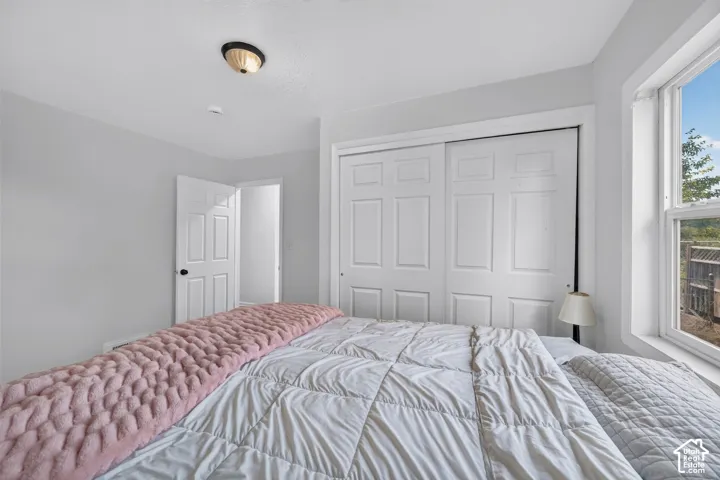 Neutral-toned room featuring a sliding-door closet, multi-panel doors, a single-hung window, and a flush-mount ceiling light fixture