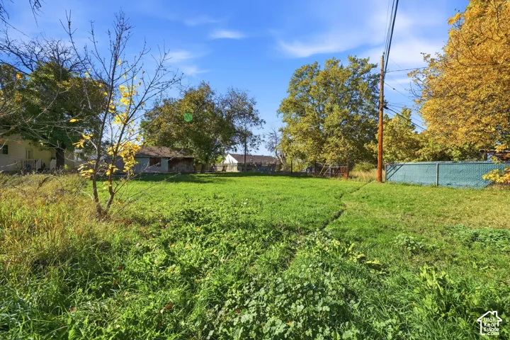 Expansive lot featuring mature trees, open grassy terrain, and perimeter fencing