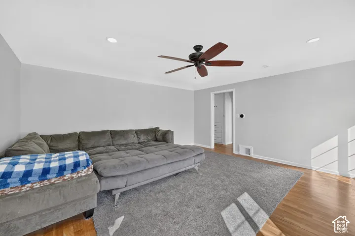 Neutral wall tones, recessed lighting, wood-finish flooring, and a ceiling fan with integrated lighting