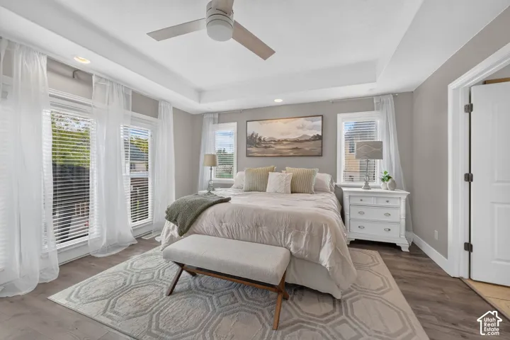 Tray ceiling, recessed lighting, wood-finish flooring, and a ceiling fan