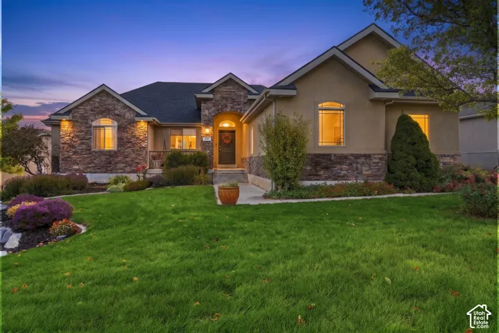 Exterior facade featuring stone veneer masonry, stucco siding, arched window detailing, and a covered entryway