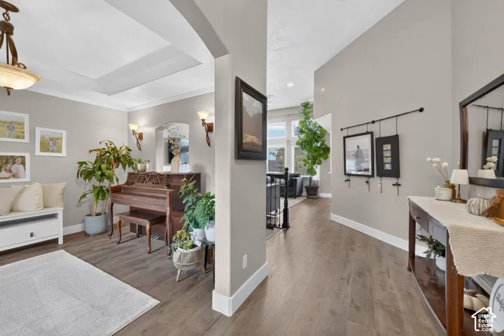 Wood-finish flooring throughout, recessed lighting, vaulted ceilings with tray detailing, and wall-mounted light fixtures