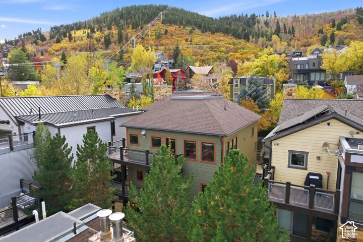 Exterior featuring shingle roofing, horizontal siding, private balconies, and mountain backdrop