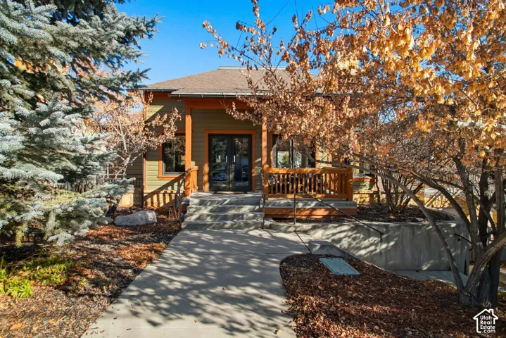 Exterior featuring horizontal siding, a covered porch with wooden railings, concrete steps, and a concrete walkway