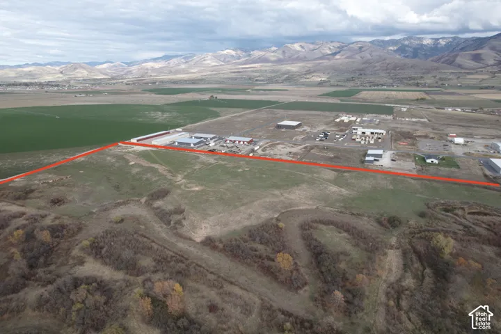 Expansive undeveloped land featuring open terrain, natural vegetation, and mountain backdrops