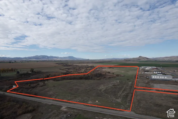 Expansive parcel of land featuring open acreage, natural vegetation, and mountain backdrop
