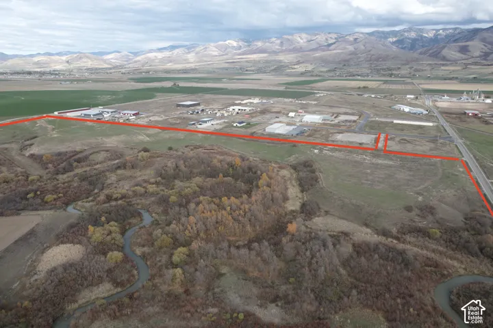 Expansive undeveloped acreage featuring mountain backdrops, natural riparian vegetation, and direct road access