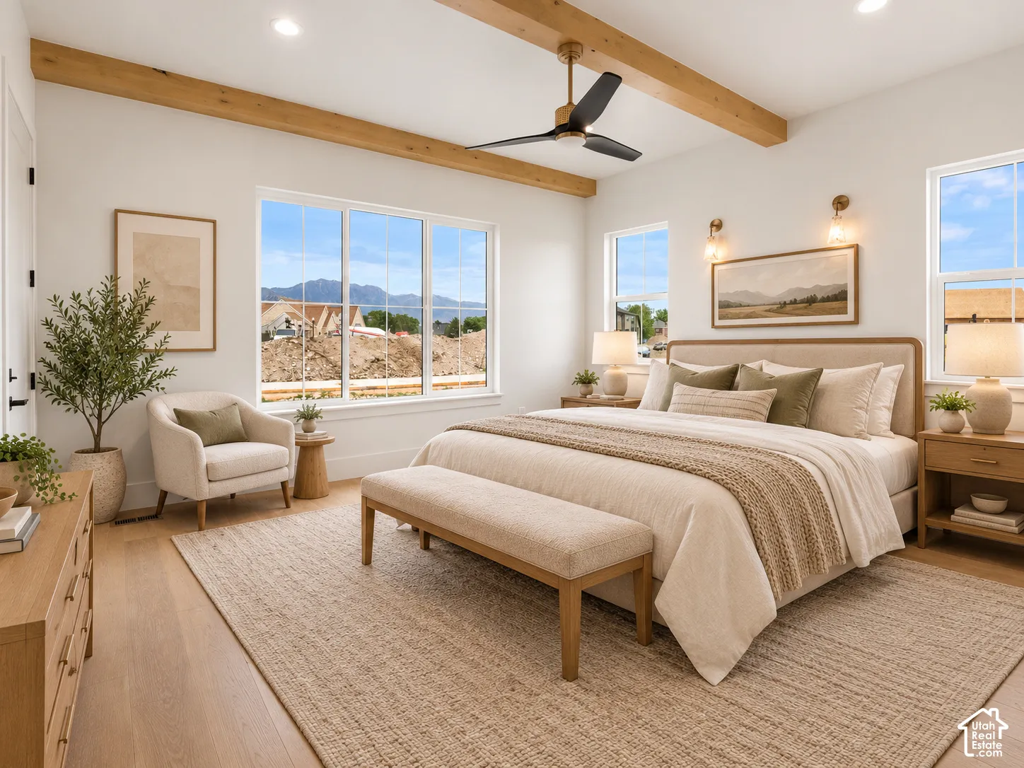 Natural light-filled room featuring prominent wood-finish ceiling beams, wood-finish flooring, a contemporary ceiling fan, and mountain scenery