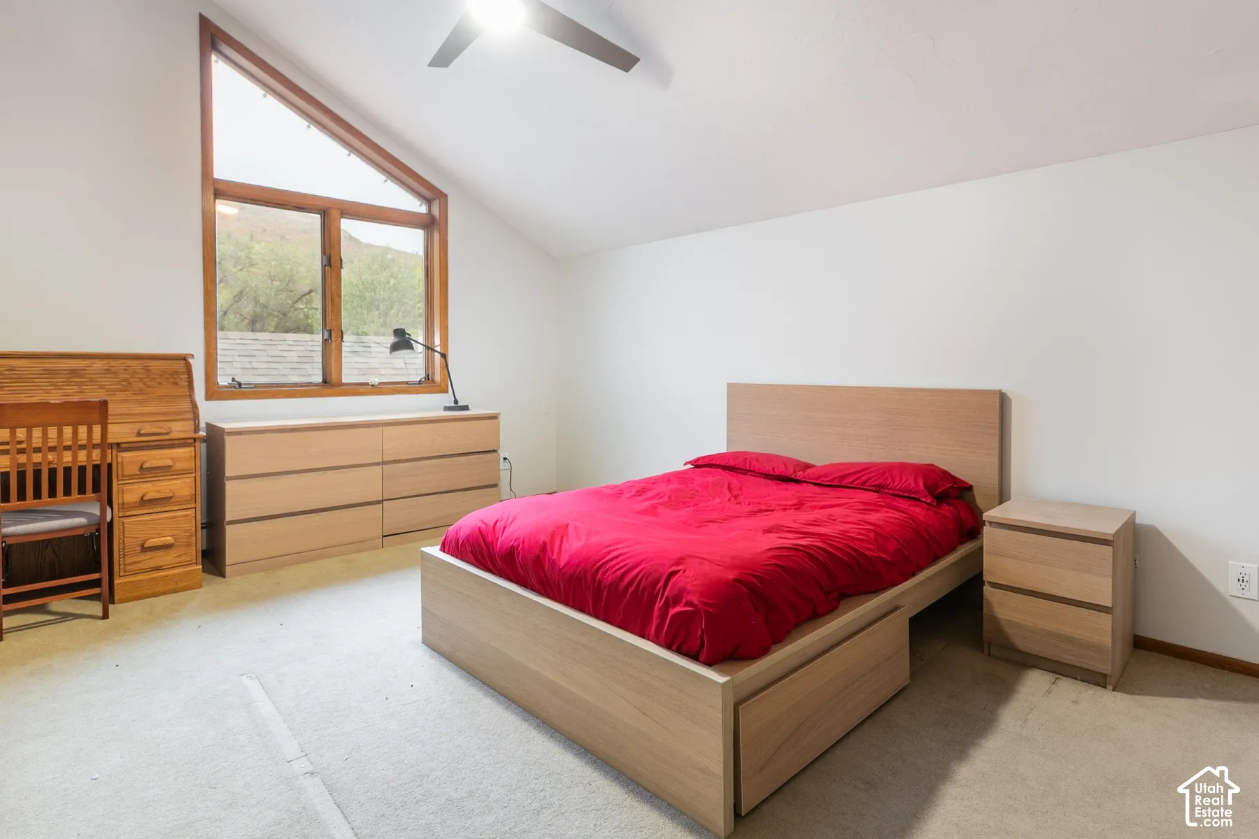 Vaulted ceilings, angular clerestory window with wood trim, and a ceiling-mounted fan