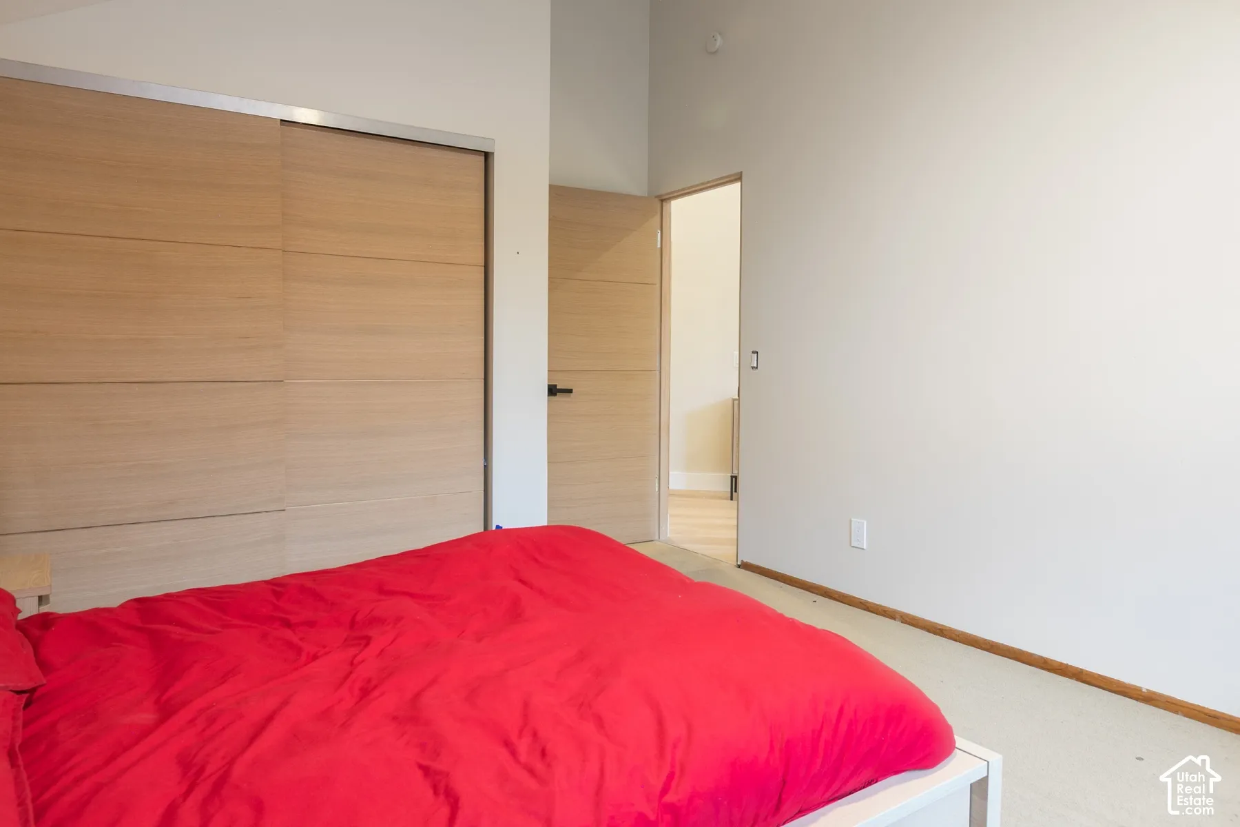 Interior room featuring high ceilings, wood-finish sliding closet doors, and modern wood-finish interior doors with matte black hardware