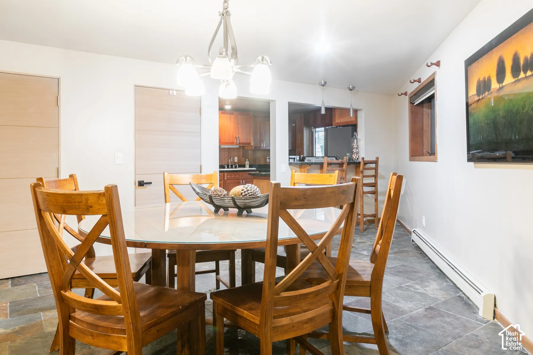 Dining area featuring natural stone tile flooring, a multi-light chandelier, and horizontal-plank interior doors