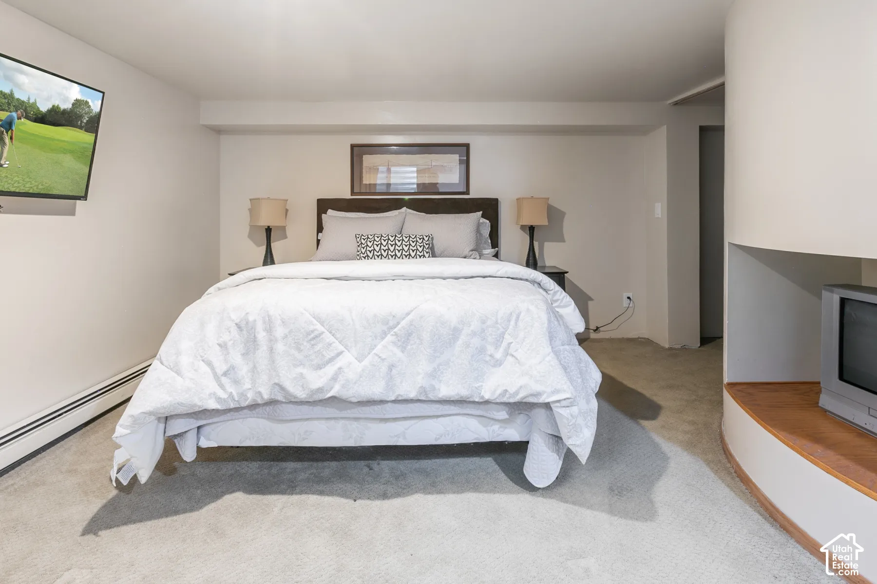 Neutral-toned interior space featuring a built-in curved wooden shelving unit and wall-to-wall carpeting