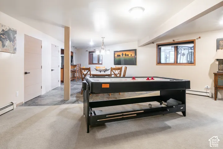 Interior space featuring neutral wall-to-wall carpeting, stone-tile flooring, solid-core interior doors, and wood-trim windows