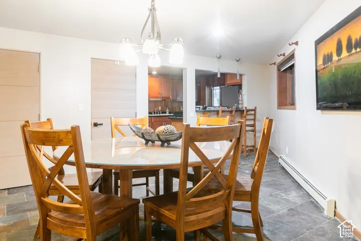 Dining area featuring natural stone tile flooring, a multi-light chandelier, and horizontal-plank interior doors