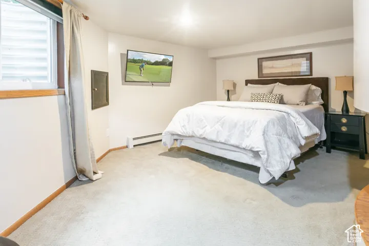 Neutral-toned interior featuring wall-to-wall carpeting, window with corrugated egress cover, and recessed ceiling lighting