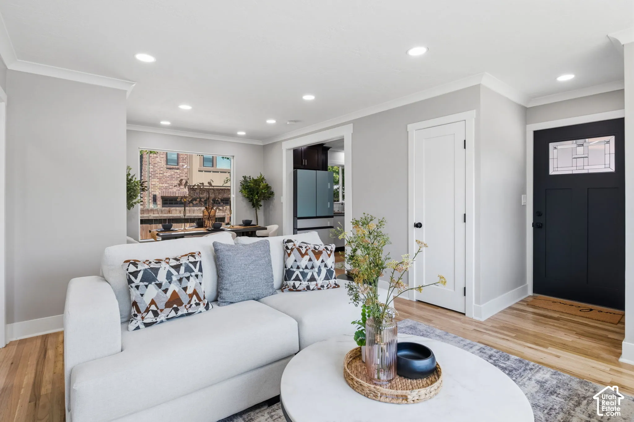 Neutral-toned interior featuring wood-finish flooring, recessed lighting, and a front entry door with a decorative glass panel