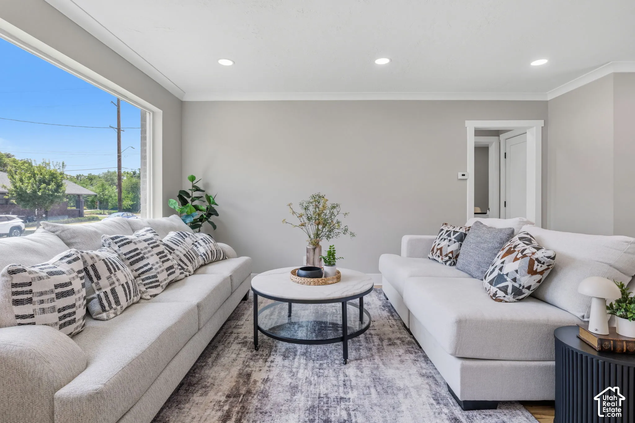 Large picture window, recessed ceiling lighting, and neutral wall color
