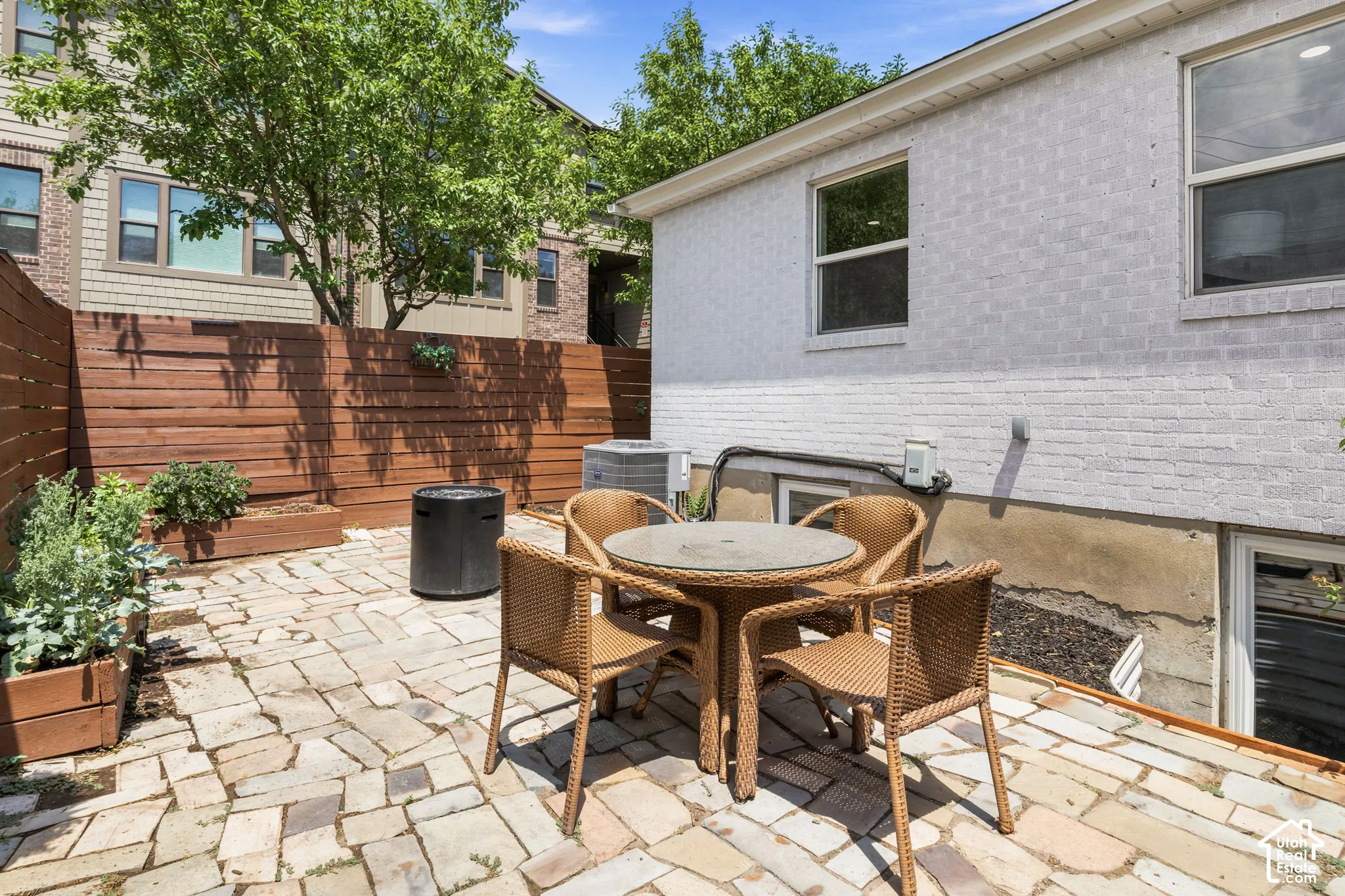 Flagstone patio, painted brick exterior, and horizontal wood privacy fencing